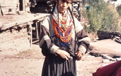 Kalasha woman her susutr head dress is studded with cowrie shells